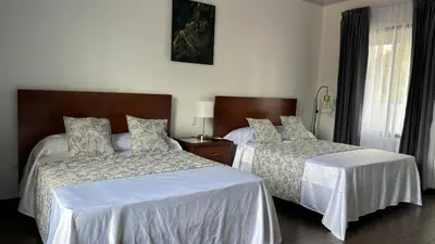 a hotel room with two beds and a window at Arenal Monara in Fortuna