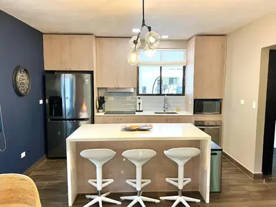 a kitchen with a large island with bar stools at Quepos Fishing Villa in Quepos