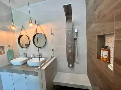 a bathroom with two sinks and two mirrors at Quepos Fishing Villa in Quepos
