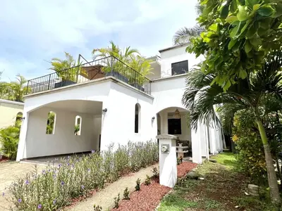a white house with a garden in front of it at Quepos Fishing Villa in Quepos