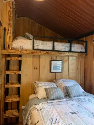 a bedroom with a bed with a wooden wall at Cabañas Tierra Fertil in Montaña