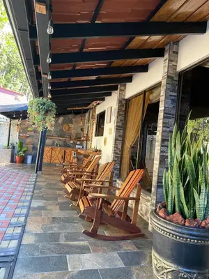 a row of wooden chairs sitting on a patio at Cabañas Tierra Fertil in Montaña