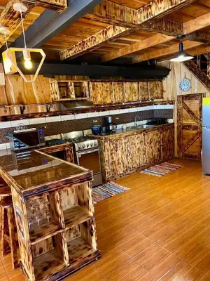 a kitchen with wooden cabinets and a counter top at Cabañas Tierra Fertil in Montaña