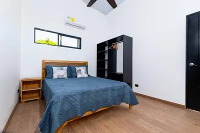 a bedroom with a bed with a blue comforter at Casa Coral - great location - high speed internet in Uvita