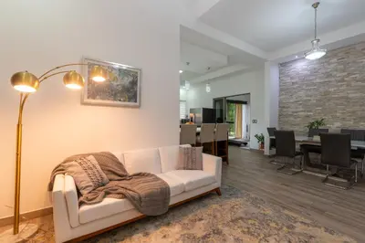 a living room with a couch and a dining room at Arenal White Bliss Villa in Fortuna