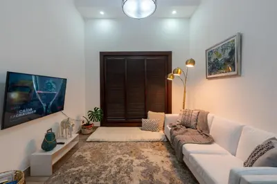 a living room with a white couch and a tv at Arenal White Bliss Villa in Fortuna
