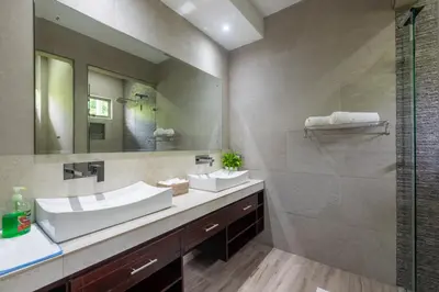 a bathroom with two sinks and a shower at Arenal White Bliss Villa in Fortuna