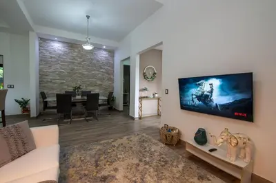 a living room with a tv on the wall at Arenal White Bliss Villa in Fortuna