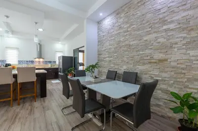a kitchen and dining room with a brick wall at Arenal White Bliss Villa in Fortuna