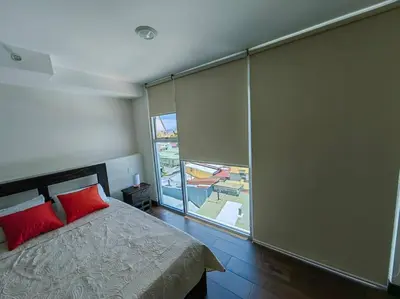 a bedroom with a bed and a large window at 706 Torres Los Yoses Hermoso apartamento en Barrio Escalante con Parqueo in San José