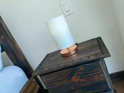 a lamp on a wooden table next to a bed at 706 Torres Los Yoses Hermoso apartamento en Barrio Escalante con Parqueo in San José