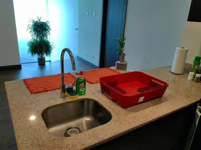 a kitchen counter with a sink and a red tray at 706 Torres Los Yoses Hermoso apartamento en Barrio Escalante con Parqueo in San José