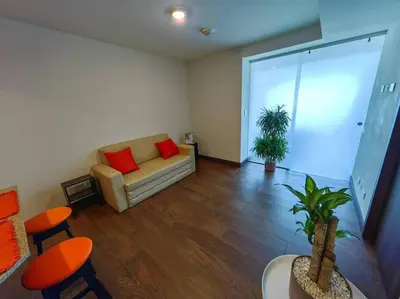 a living room with a couch with two red pillows at 706 Torres Los Yoses Hermoso apartamento en Barrio Escalante con Parqueo in San José