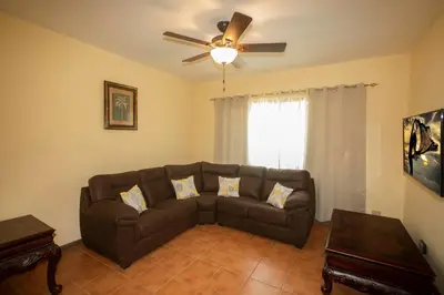 a living room with a couch and a ceiling fan at Three Bedroom Sunny Townhome in Coco