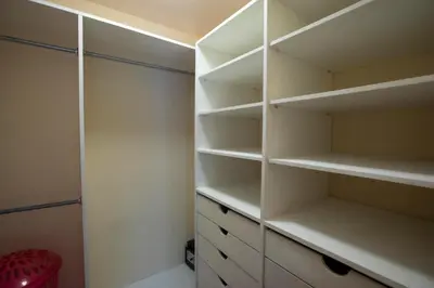 a white walk in closet with white shelves at Three Bedroom Sunny Townhome in Coco