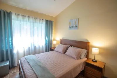 a bedroom with a bed with two lamps and a window at Three Bedroom Sunny Townhome in Coco