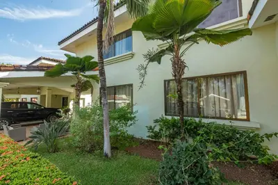 a house with palm trees in front of it at Three Bedroom Sunny Townhome in Coco