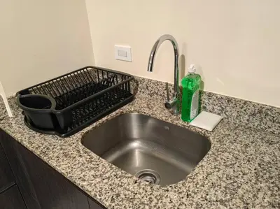 a kitchen sink with a dish drying rack next to it at 1001 Torres Los Yoses Apartamento con A/C y parqueo full equipado in San José