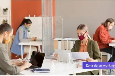 a woman wearing a face mask sitting at a table with a laptop at 1001 Torres Los Yoses Apartamento con A/C y parqueo full equipado in San José