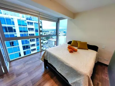 a bedroom with a bed and a large window at 1505 Torre los Yoses Hermoso Apartamento en Barrio Escalante con Parqueo in San José