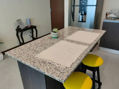a kitchen island with two stools and a counter top at 1505 Torre los Yoses Hermoso Apartamento en Barrio Escalante con Parqueo in San José