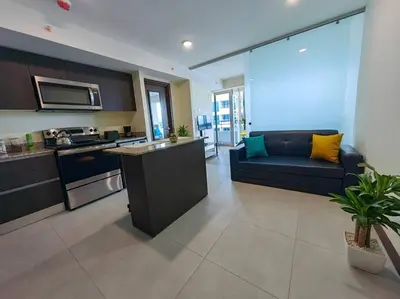a kitchen and living room with a blue couch in a room at 1505 Torre los Yoses Hermoso Apartamento en Barrio Escalante con Parqueo in San José