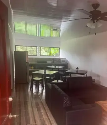 a living room with a couch and tables and windows at Sky Hostel in Fortuna