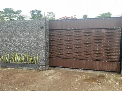 a fence with a wooden gate with some plants at Sky Hostel in Fortuna