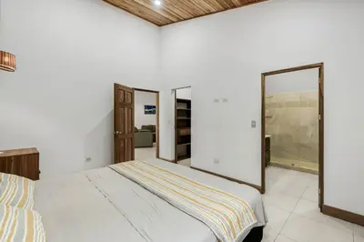 a bedroom with a bed and two mirrors at Stylish 3-Bedroom Tropical Escape with Pool & Outdoor Living, 1 Block from Playa Potrero in Potrero