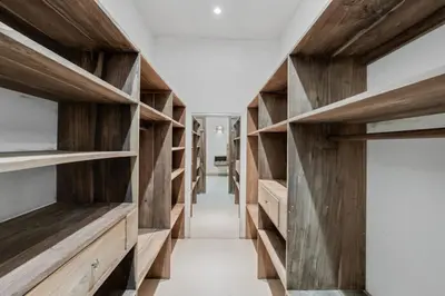 a room with wooden shelves and a hallway at Stylish 3-Bedroom Tropical Escape with Pool & Outdoor Living, 1 Block from Playa Potrero in Potrero