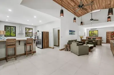 a large living room with a kitchen and a living room at Stylish 3-Bedroom Tropical Escape with Pool & Outdoor Living, 1 Block from Playa Potrero in Potrero