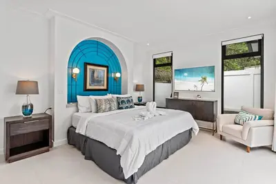 a large bedroom with a large bed and a chair at Modern Garden Villa with Private Pool, Outdoor Kitchen & Separate Casita Near Playa Potrero in Potrero