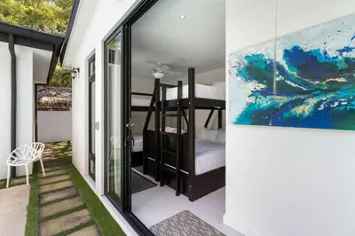 a bedroom with a bunk bed and a painting on the wall at Modern Garden Villa with Private Pool, Outdoor Kitchen & Separate Casita Near Playa Potrero in Potrero