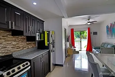 a kitchen with black cabinets and a living room at 2-BD Unit with Pool 2 Blocks from Beach in Coco