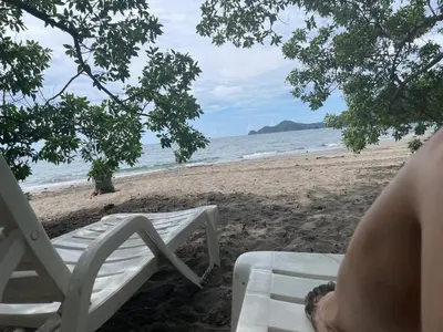 a person sitting on a chair on the beach at Villa Hermosa in Playa Hermosa