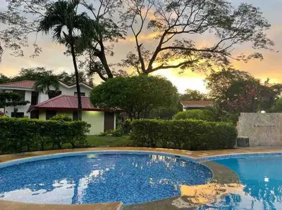 a swimming pool in front of a house at Villa Hermosa in Playa Hermosa