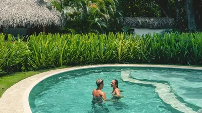 two people are standing in a swimming pool at Playa Cielo Beachfront Hotel - Santa Teresa, Costa Rica in Santa Teresa Beach