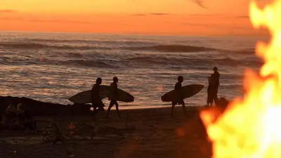 a group of people walking on the beach with surfboards at Playa Cielo Beachfront Hotel - Santa Teresa, Costa Rica in Santa Teresa Beach