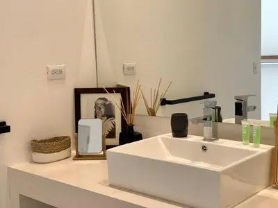 a bathroom with a white sink and a mirror at Les Roches - Paradise Retreat in Santa Teresa Beach