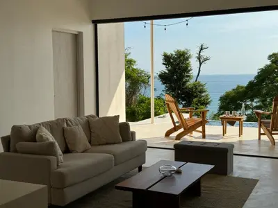 a living room with a couch and a table at Les Roches - Paradise Retreat in Santa Teresa Beach