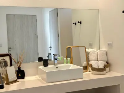 a bathroom with a white sink and a mirror at Les Roches - Paradise Retreat in Santa Teresa Beach