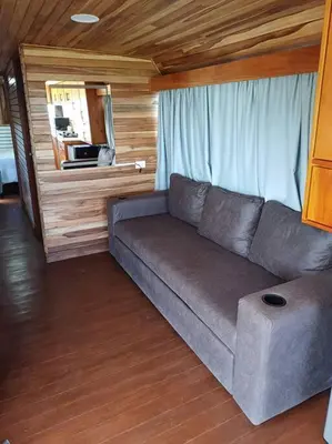 a couch in a living room with a window at BusHotel Poás con Jacuzzi y Chimenea in Fraijanes