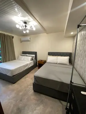 a bedroom with two beds and a ceiling fan at Oasis by Franklin Hotel Boutique in Fortuna