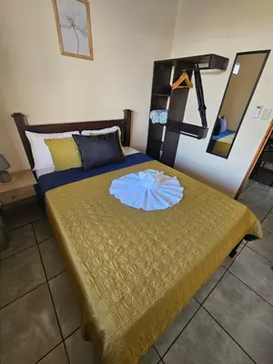 a bedroom with a bed with a flower on it at Arenal Paradise Lodge in Fortuna