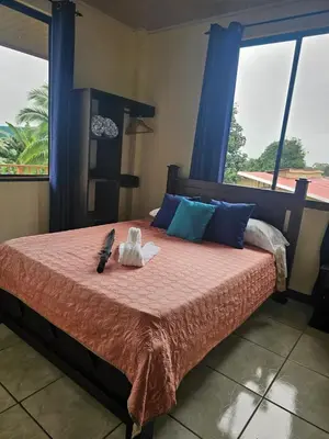 a bedroom with a bed with a stuffed animal on it at Arenal Paradise Lodge in Fortuna