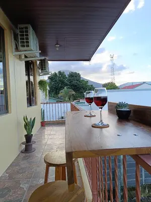 two glasses of wine sitting on a wooden table at Arenal Paradise Lodge in Fortuna