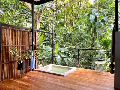 a hot tub on a wooden deck with trees at Industrial Studio with private Jacuzzi in Uvita