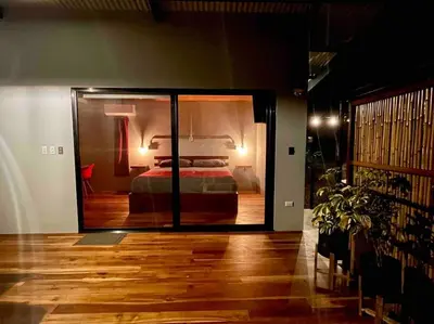 a bedroom with a bed through a glass door at Industrial Studio with private Jacuzzi in Uvita