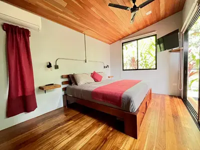 a bedroom with a bed in a room with a window at Industrial Studio with private Jacuzzi in Uvita
