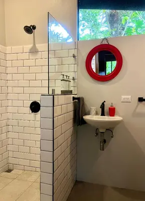 a bathroom with a sink and a red mirror at Industrial Studio with private Jacuzzi in Uvita
